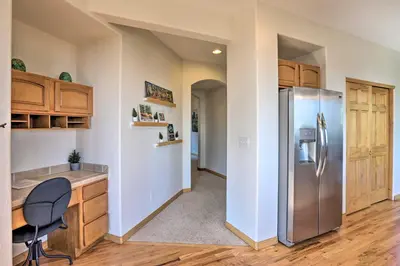 a kitchen with a stainless steel refrigerator and wooden cabinets at Spacious Evergreen Home with Picturesque Views in Evergreen