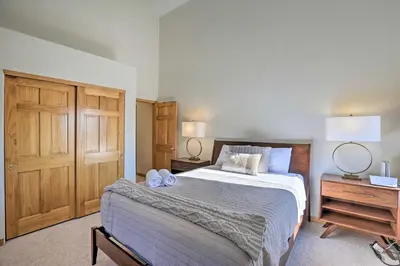 a bedroom with a large bed and a wooden cabinet at Spacious Evergreen Home with Picturesque Views in Evergreen