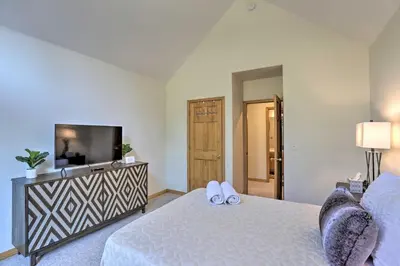 a bedroom with a bed and a flat screen tv at Spacious Evergreen Home with Picturesque Views in Evergreen