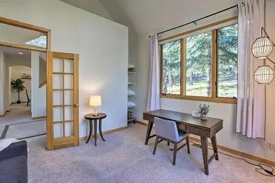 a living room with a table and a window at Spacious Evergreen Home with Picturesque Views in Evergreen
