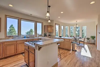 a large kitchen with wooden cabinets and a large island at Spacious Evergreen Home with Picturesque Views in Evergreen