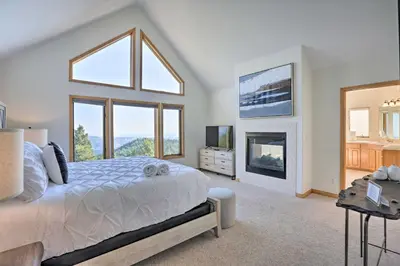 a bedroom with a large bed and a fireplace at Spacious Evergreen Home with Picturesque Views in Evergreen