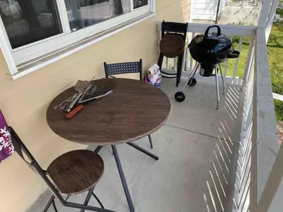 a table and chairs on a porch with a grill at 2br 1 bath Upstairs AC WD Barnum West Near Belmar in Denver