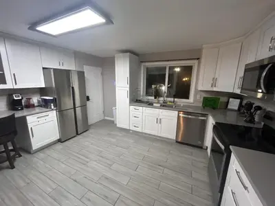 a kitchen with white cabinets and stainless steel appliances at 2br 1 bath Upstairs AC WD Barnum West Near Belmar in Denver