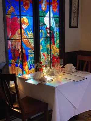 a white table with a stained glass window behind it at Inn of Glen Haven in Glen Haven