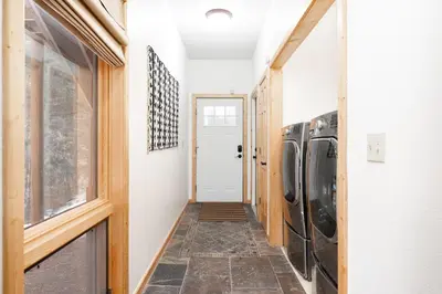 a hallway leading to a laundry room with two washers at Iconic Log Cabin Escape - Idaho Springs - Hot Tub in Idaho Springs