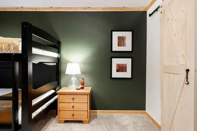a bedroom with a bunk bed and a table with a lamp at Iconic Log Cabin Escape - Idaho Springs - Hot Tub in Idaho Springs