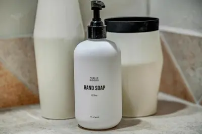 a bottle of hand soap sitting next to a container at Iconic Log Cabin Escape - Idaho Springs - Hot Tub in Idaho Springs