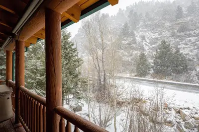 a porch with a view of a snow covered road at Iconic Log Cabin Escape - Idaho Springs - Hot Tub in Idaho Springs