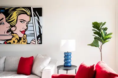 a living room with a couch and a painting on the wall at Art-Inspired Loft with Mountain View - Zuni Lofts in Denver