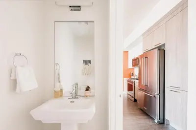 a white kitchen with a sink and a refrigerator at Gallery Retreat - Skyline Views - Zuni Lofts in Denver