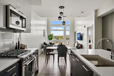 a kitchen with a table and a dining room at Modern Eclectic Penthouse Loft - Zuni Lofts in Denver