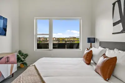 a bedroom with a bed and a large window at Modern Eclectic Penthouse Loft - Zuni Lofts in Denver