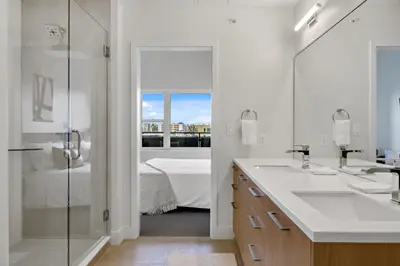 a white bathroom with two sinks and a shower at Modern Eclectic Penthouse Loft - Zuni Lofts in Denver