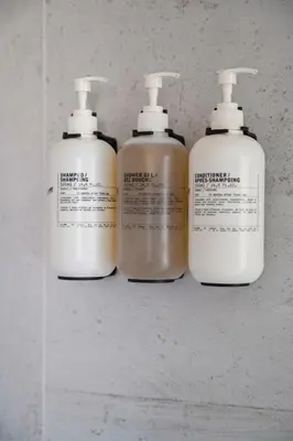 a group of three lotion bottles on a shelf at Modern Eclectic Penthouse Loft - Zuni Lofts in Denver