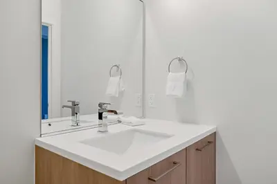 a bathroom with a white sink and a mirror at Modern Eclectic Penthouse Loft - Zuni Lofts in Denver