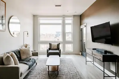 a living room with a couch and a flat screen tv at Contemporary Cool Lifestyle Loft - Zuni Lofts in Denver