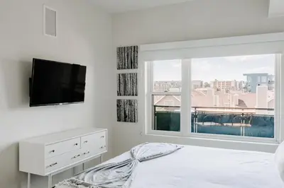 a bedroom with a bed and a large window at Contemporary Cool Lifestyle Loft - Zuni Lofts in Denver