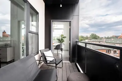 a balcony with two chairs and a large window at A Luxe Point of View - Pet-Friendly - Zuni Lofts in Denver