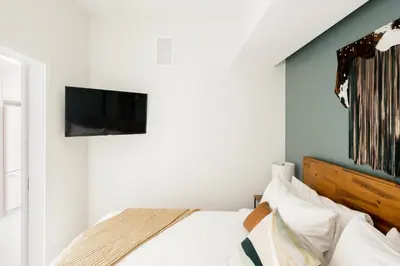 a bedroom with a bed with a tv on the wall at Colorful Western Vibe - Pet-Friendly - Zuni Lofts in Denver