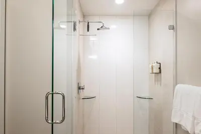 a shower with a glass door in a bathroom at Colorful Western Vibe - Pet-Friendly - Zuni Lofts in Denver