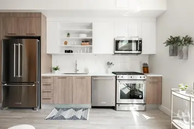 a kitchen with stainless steel appliances and wooden cabinets at Colorful Western Vibe - Pet-Friendly - Zuni Lofts in Denver