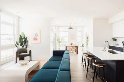 a living room with a blue couch and a kitchen at LoHi Clubhouse - Cityscape Panorama - Central LoHi in Denver
