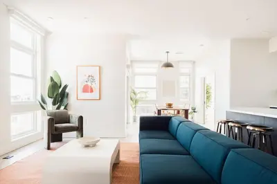 a living room with a blue couch and a table at LoHi Clubhouse - Cityscape Panorama - Central LoHi in Denver