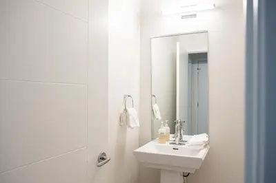 a white bathroom with a sink and a mirror at LoHi Clubhouse - Cityscape Panorama - Central LoHi in Denver