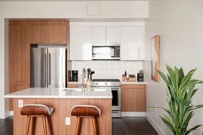 a kitchen with white appliances and wooden cabinets at Modern Lifestyle - City View - Pet-Friendly - Zuni in Denver