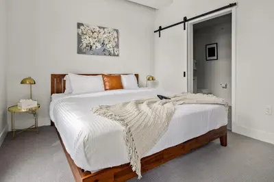 a bedroom with a large bed with white sheets at On Cloud 9 - Curated Lifestyle Loft - Zuni Lofts in Denver