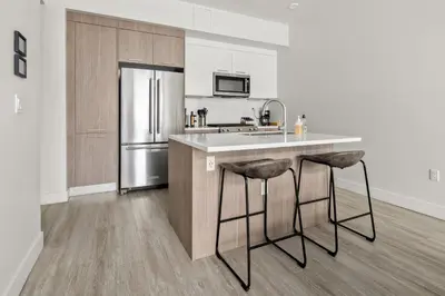 a kitchen with a counter and a refrigerator at On Cloud 9 - Curated Lifestyle Loft - Zuni Lofts in Denver