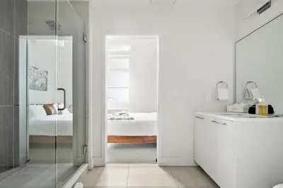 a bathroom with a glass door leading to a bedroom at On Cloud 9 - Curated Lifestyle Loft - Zuni Lofts in Denver