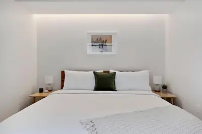 a white bedroom with a large bed with white pillows at Modern Lifestyle Loft with View - Zuni Lofts in Denver