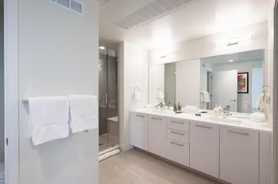 a white bathroom with two sinks and a mirror at Skyline Loft - Sweeping Views - Central LoHi in Denver