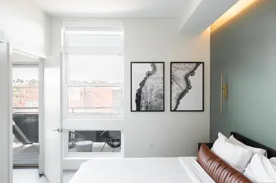 a bedroom with a bed with three pictures on the wall at New Spacious Modern Loft - Center of LoHi in Denver