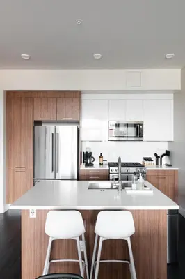 a kitchen with a large white island with two bar stools at New Spacious Modern Loft - Center of LoHi in Denver