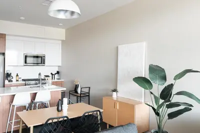 a kitchen with two tables and a potted plant at New Spacious Modern Loft - Center of LoHi in Denver