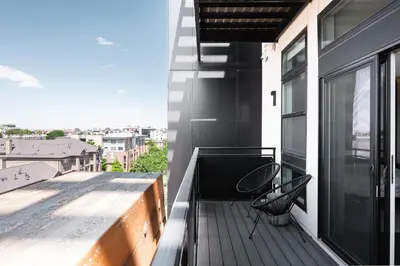 a balcony with two chairs on a building at New Spacious Modern Loft - Center of LoHi in Denver
