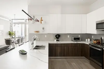 a kitchen with white cabinets and a counter top at Walk to Gameday - Jefferson Park Condo - Tesoro in Denver