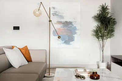 a living room with a couch and a floor lamp at Walk to Gameday - Jefferson Park Condo - Tesoro in Denver