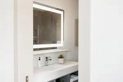 a bathroom with a sink and a mirror at Walk to Gameday - Jefferson Park Condo - Tesoro in Denver