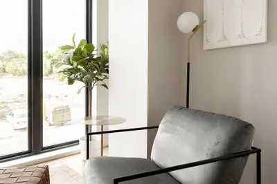 a living room with a chair and a table at Walk to Gameday - Jefferson Park Condo - Tesoro in Denver