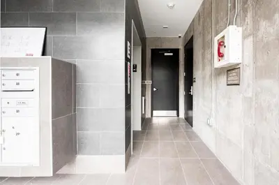 a hallway with a tile floor and a hallway with a black door at City Views! - Chic Jefferson Park Condo - Tesoro in Denver