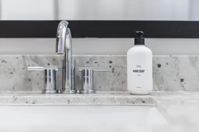 a bottle of liquid soap sitting on a kitchen sink at Urban Oasis - Rooftop Delight - Peloton - RiNo in Denver