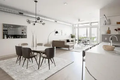 a kitchen and living room with a table and chairs at Gameday Oasis - Private Balcony - Jefferson Park - Tesoro in Denver
