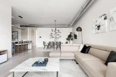 a living room with a white couch and a table at Gameday Oasis - Private Balcony - Jefferson Park - Tesoro in Denver