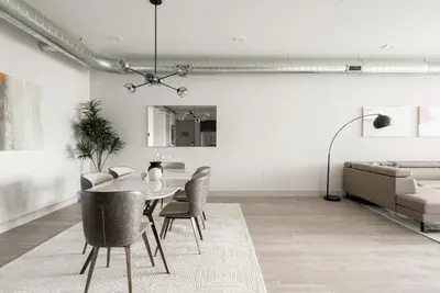 a dining room with a table and chairs and a couch at Luxurious Escape - Walk to Empower Field - Tesoro in Denver