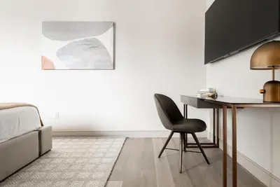 a bedroom with a desk and a chair next to a bed at Luxurious Escape - Walk to Empower Field - Tesoro in Denver