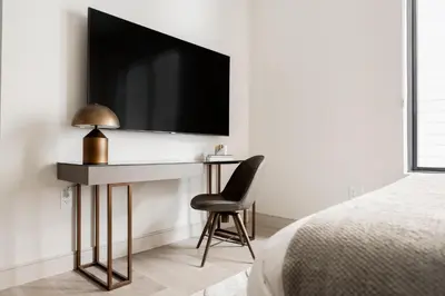a bedroom with a desk with a television on a wall at Brand New Condo - Walk to Empower Stadium - Tesoro in Denver